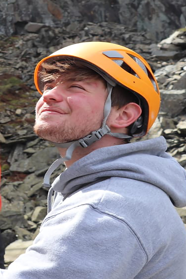 A man in an orange helmet looking up